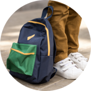 A child wearing brown pants and white shoes is pictured next to a back pack, representing the unpacking cancer from the back pack webinar.