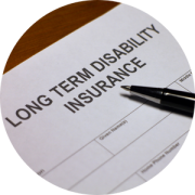 Long-Term Disability Insurance paperwork, with a pen laying on top of it.