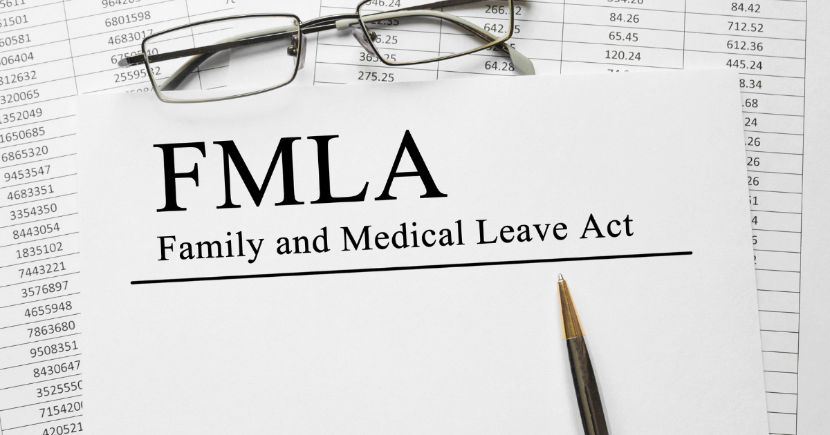 A form with the words "FMLA, FAMILY AND MEDICAL LEAVE ACT." A pen is sitting on the form, and a pair of glasses.