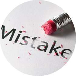 the word "mistake is typed on a piece of paper with a pencil eraser pointing at it.