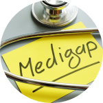 The word "Medigap" is written on a yellow sticky note with a stethoscope wrapped around it.
