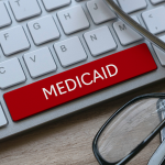A keyboard with a bright red "medicaid" key in place of the space bar.