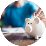 A person places a coin in a white piggy bank