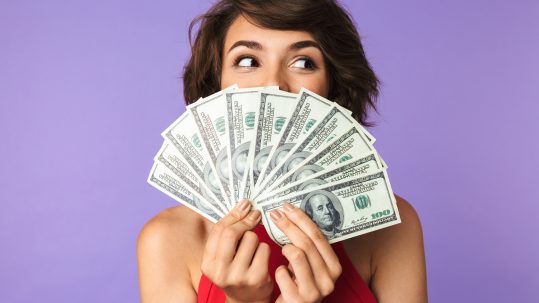 Female student fanning money saved for student loans for payment plan