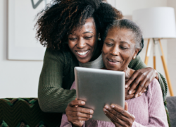 Two Black women reviewing content on a tablet.